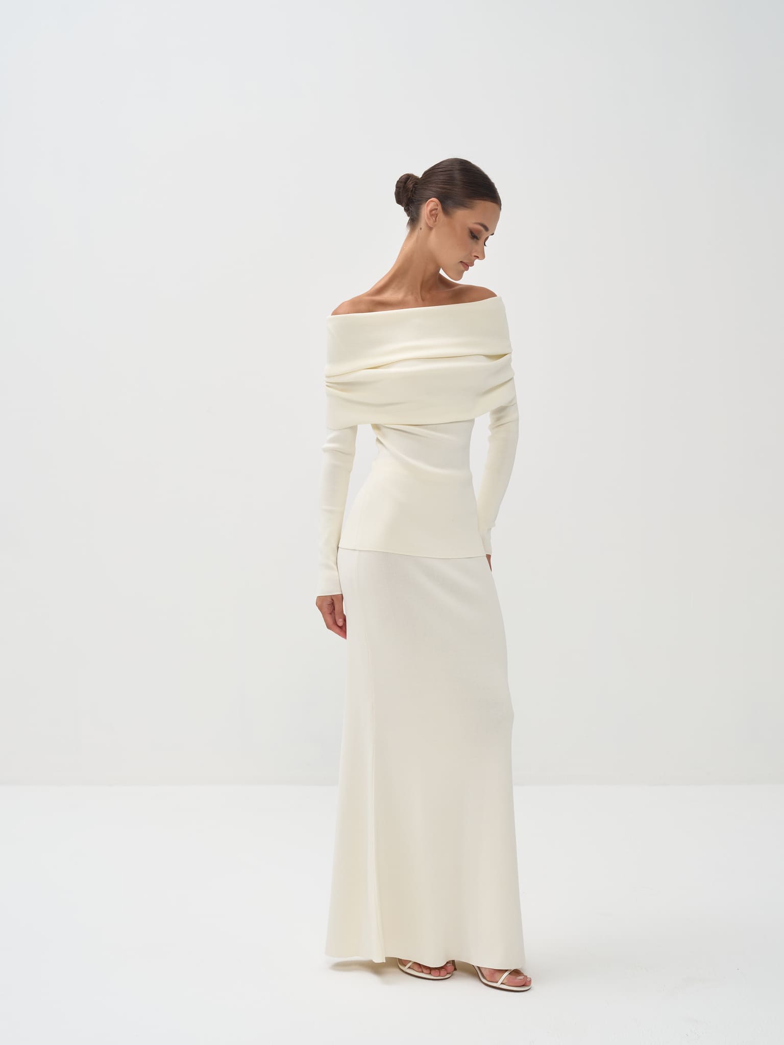 Woman wearing a white off-shoulder dress on a white background