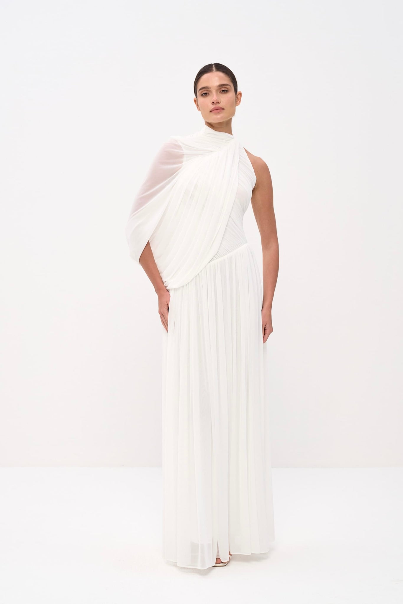 Woman wearing a white dress with a draped top on a white background