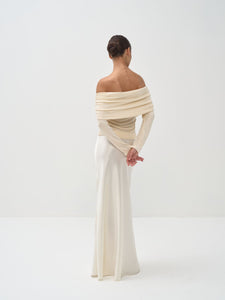 Woman wearing a stylish off-shoulder top and skirt on a white background