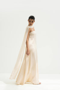 Woman wearing a strapless white gown with a long scarf on a white background