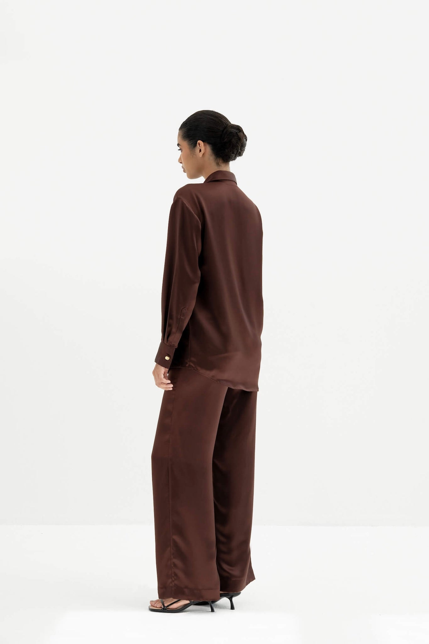 Person wearing a brown outfit on a white background
