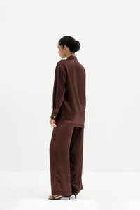 Person wearing a brown outfit on a white background