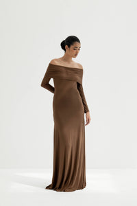 Woman wearing a brown off-shoulder gown on a white background