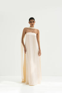Woman wearing a strapless white gown with a long scarf on a white background