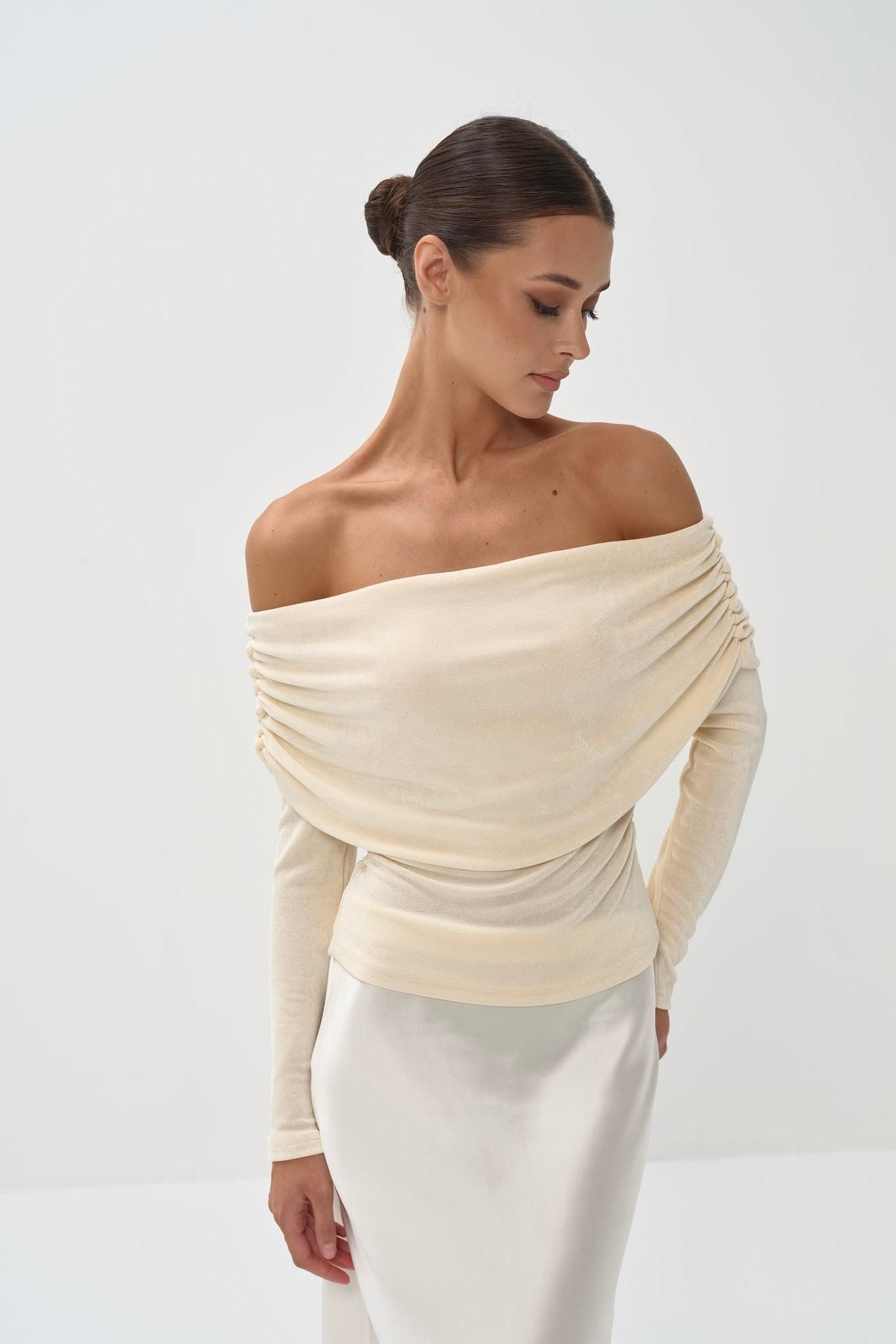Person wearing a long, light-colored skirt and top on a white background