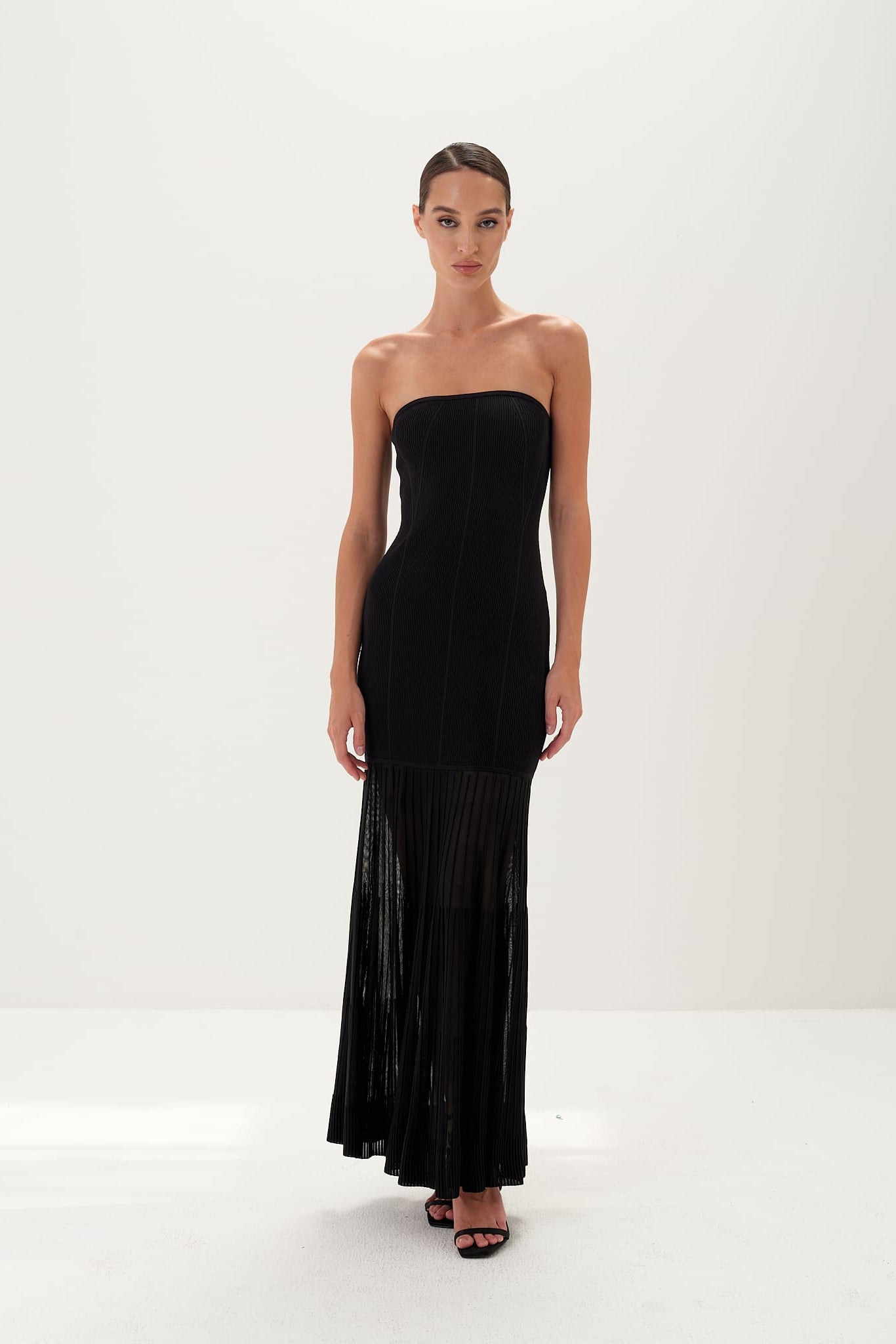 Woman wearing a black dress with a sheer panel on a white background