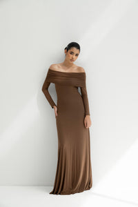 Woman wearing a brown off-shoulder dress against a white background