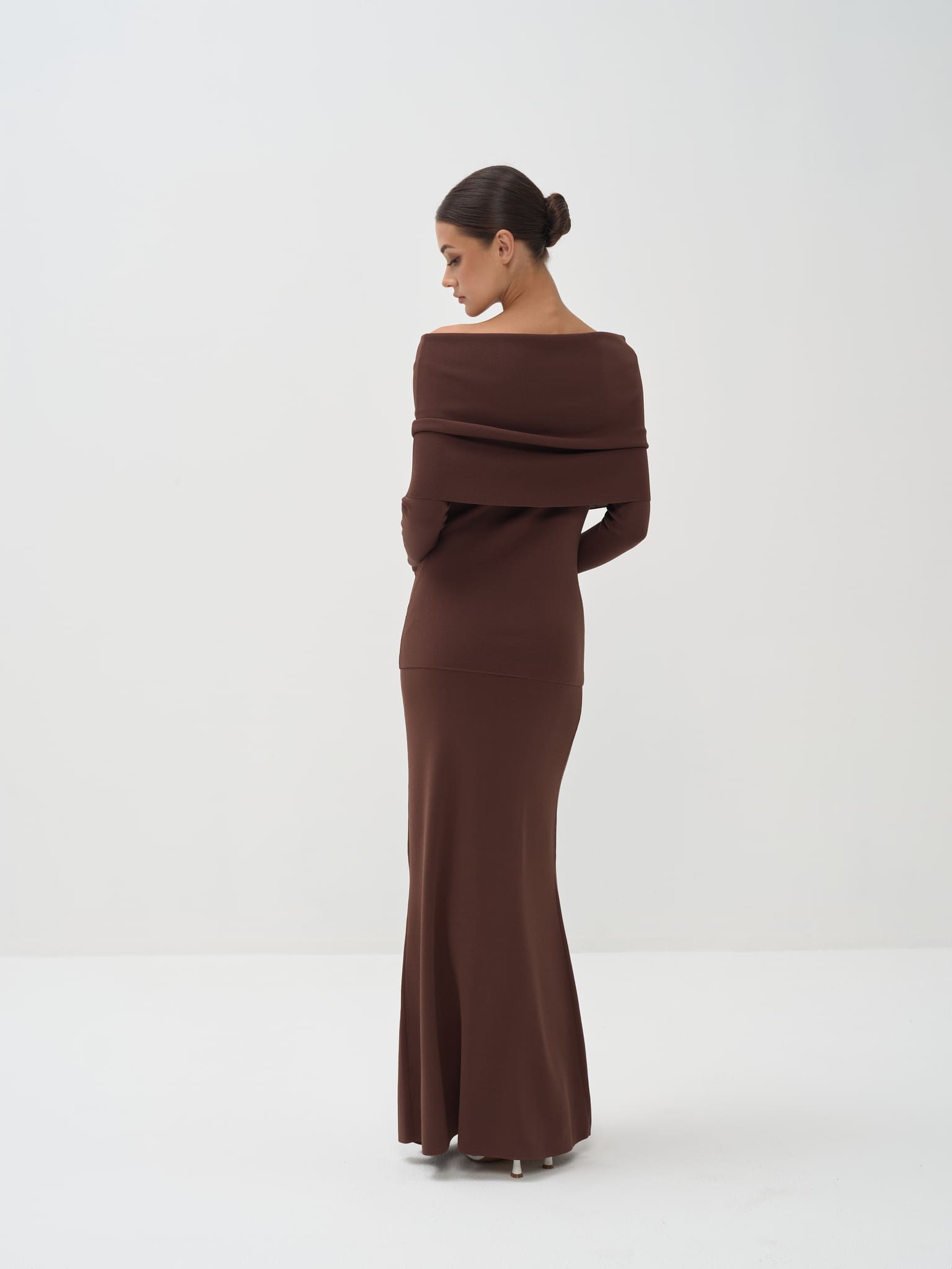 Woman wearing a brown off-shoulder dress on a white background