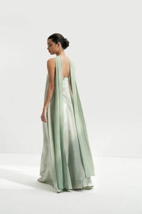 Woman wearing a strapless light green gown with a long scarf on a white background