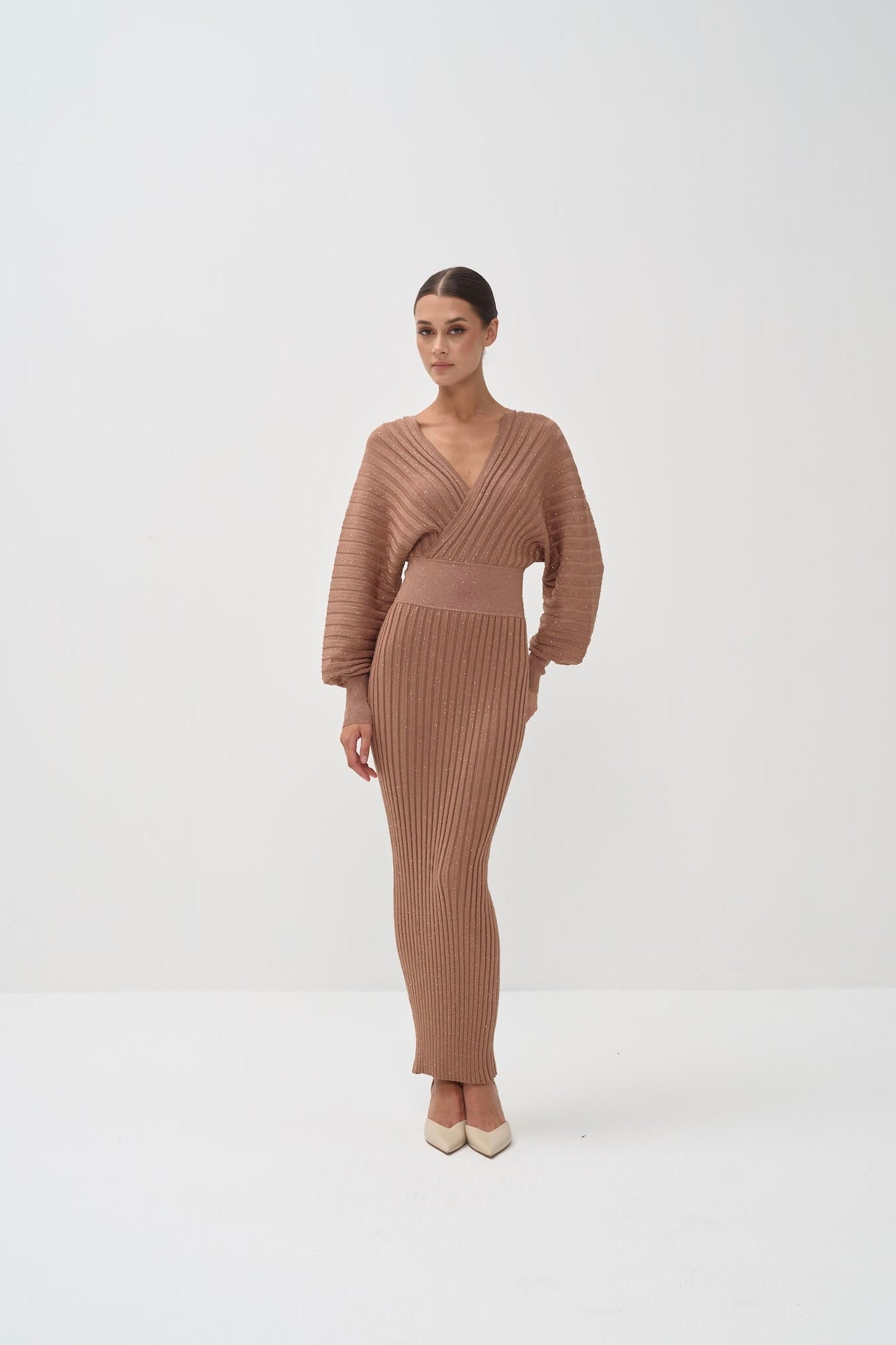 Woman wearing a brown ribbed knit dress on a white background