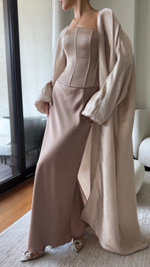 The model is wearing a rosy pink Aerin Abaya on top of the Silky Regina Corset set presenting a refined and fashionable appearance with a touch of elegance.