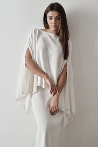 Model wearing Amanda Set featuring a draped cape top and a matching floor-length skirt, styled with white strappy sandals, standing against a white background