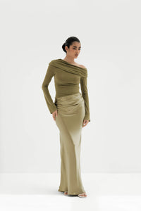 Woman wearing a green off-shoulder dress on a white background