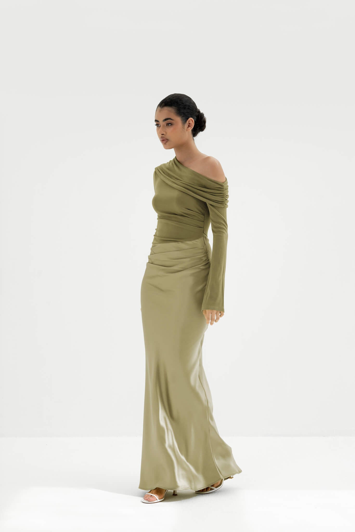 Woman wearing a green off-shoulder dress on a white background