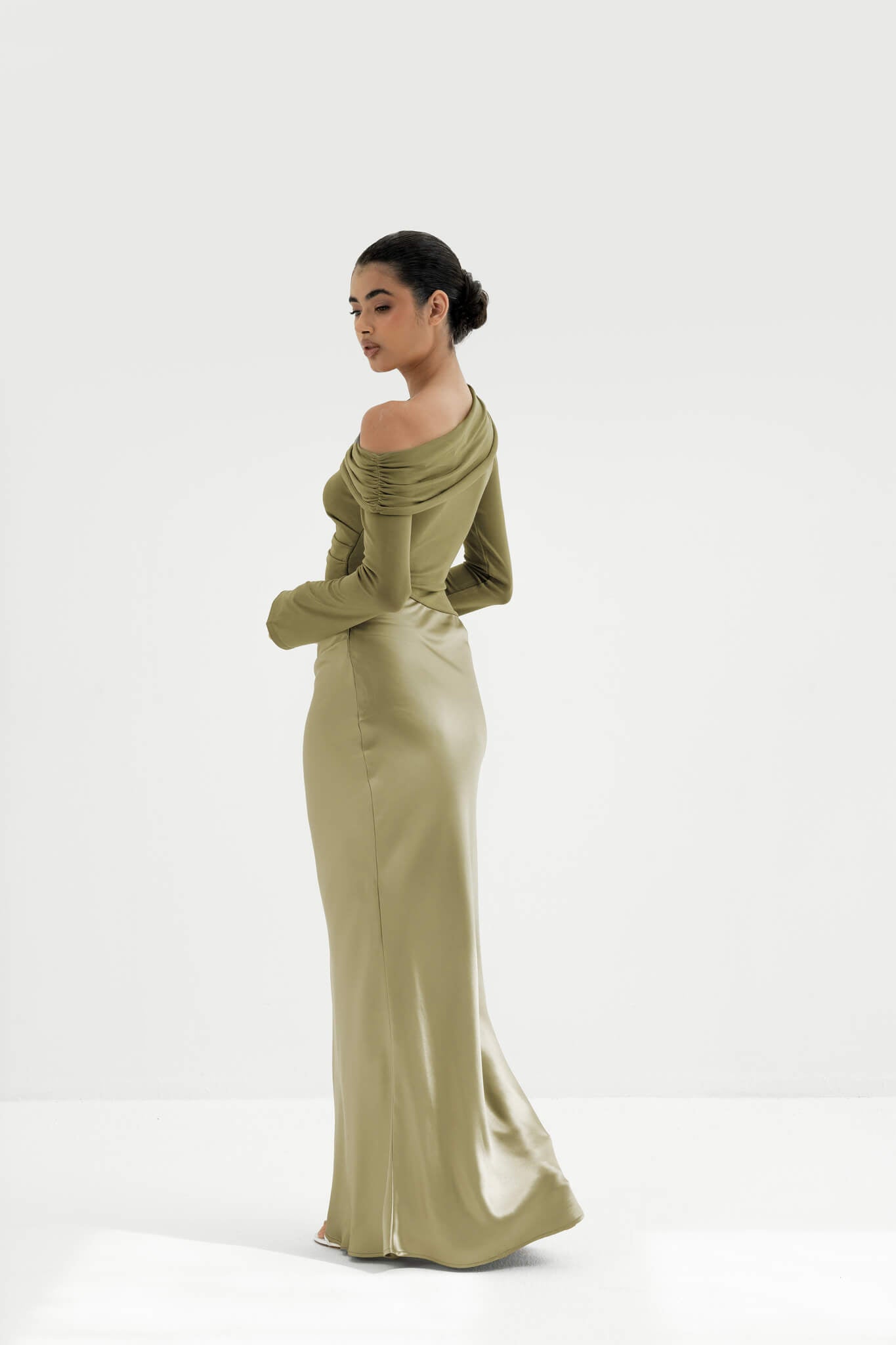Woman wearing a green off-shoulder dress on a white background