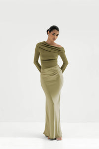 Woman wearing a green off-shoulder dress on a white background