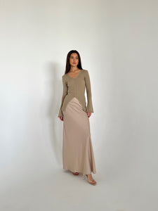 A woman in a flowing dress and heels, highlighting the Elara knit top, exuding grace and sophistication.