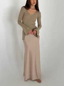 A woman in a flowing dress and heels, highlighting the Elara knit top, exuding grace and sophistication.