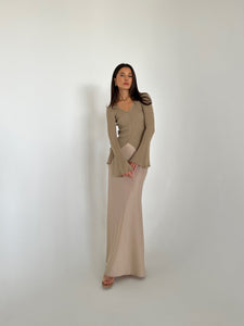 A woman in a flowing dress and heels, highlighting the Elara knit top, exuding grace and sophistication.