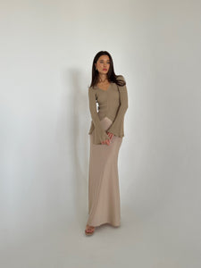 A woman in a flowing dress and heels, highlighting the Elara knit top, exuding grace and sophistication.