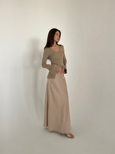 A woman in a flowing dress and heels, highlighting the Elara knit top, exuding grace and sophistication.