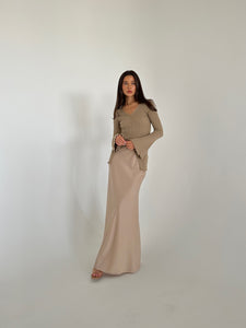 A woman in a flowing dress and heels, highlighting the Elara knit top, exuding grace and sophistication.