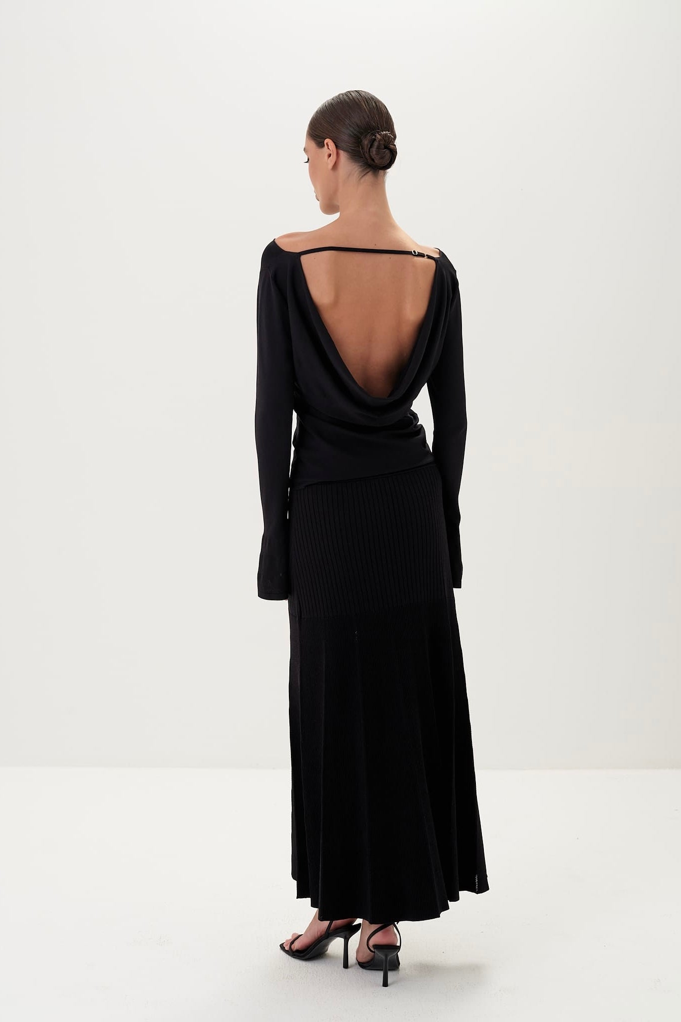Black evening gown with open back on a white background
