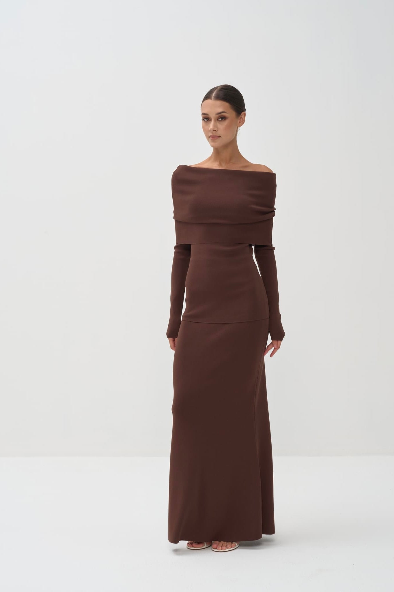 Woman wearing a brown off-shoulder set on a white background