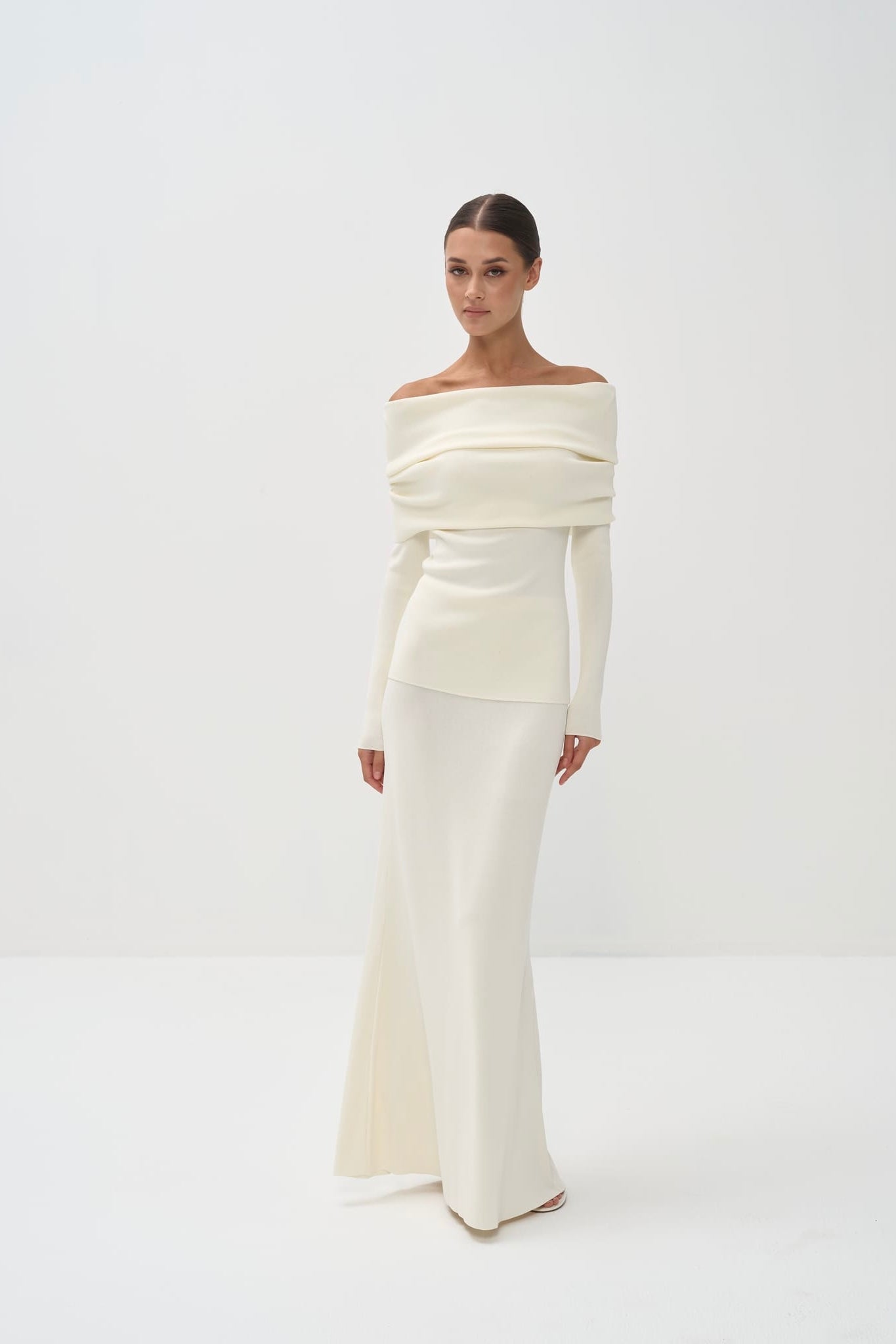Woman wearing a white off-shoulder set against a white background