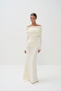 Woman wearing a white off-shoulder set against a white background