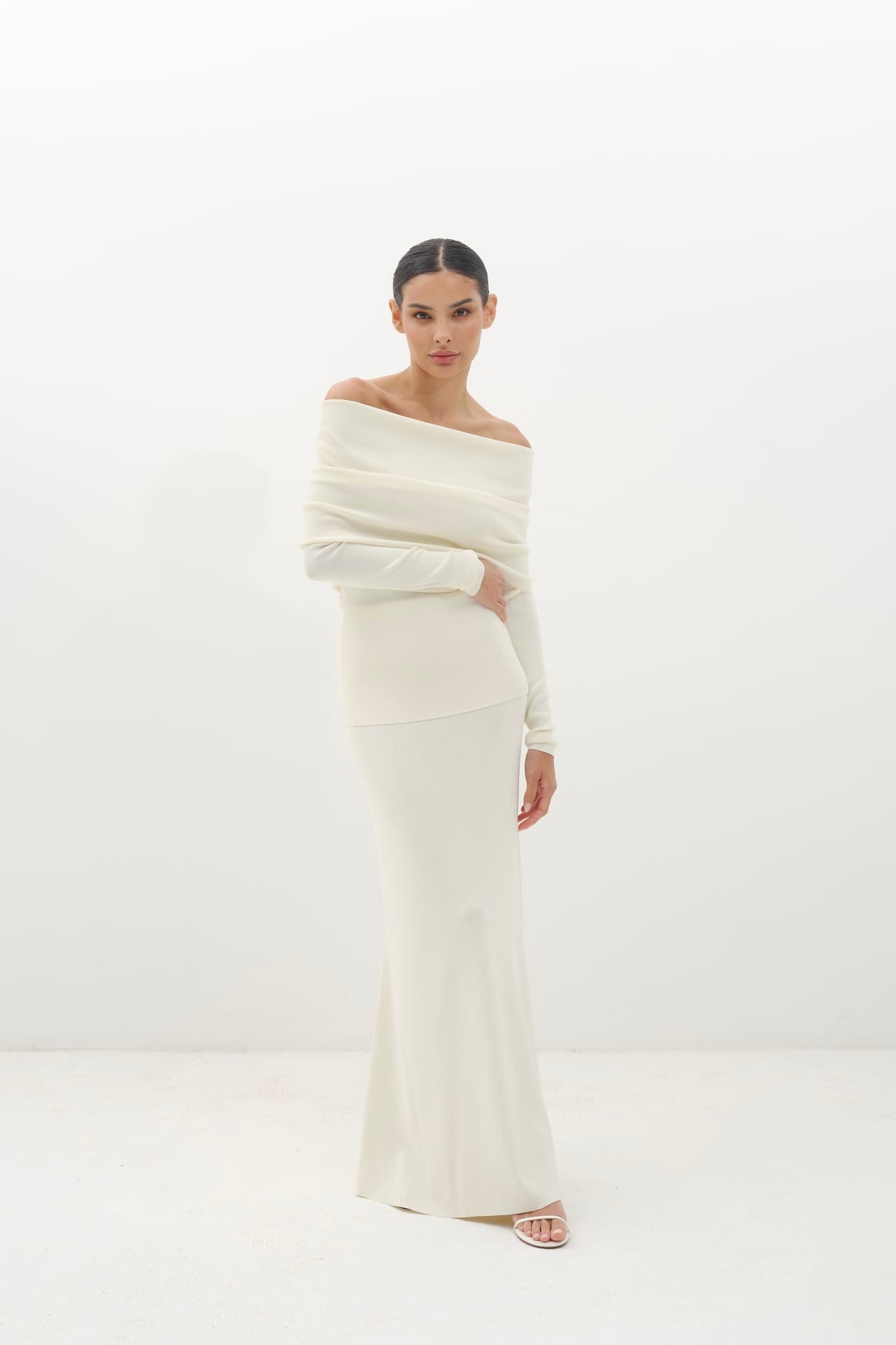 Woman wearing a white off-shoulder set against a white background
