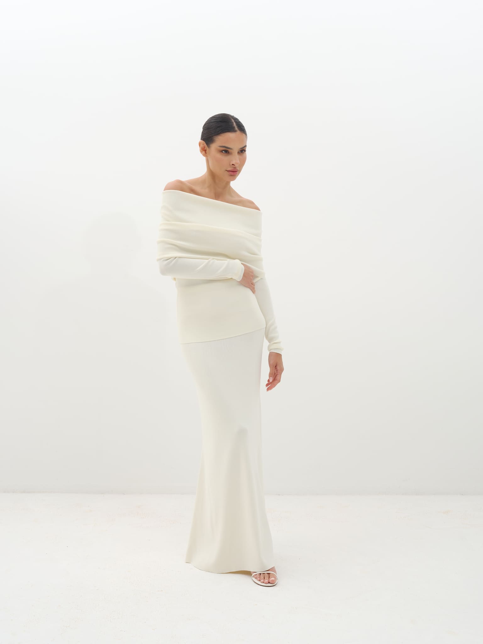 Woman wearing a white off-shoulder set against a white background