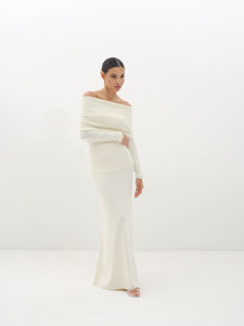 Woman wearing a white off-shoulder set against a white background