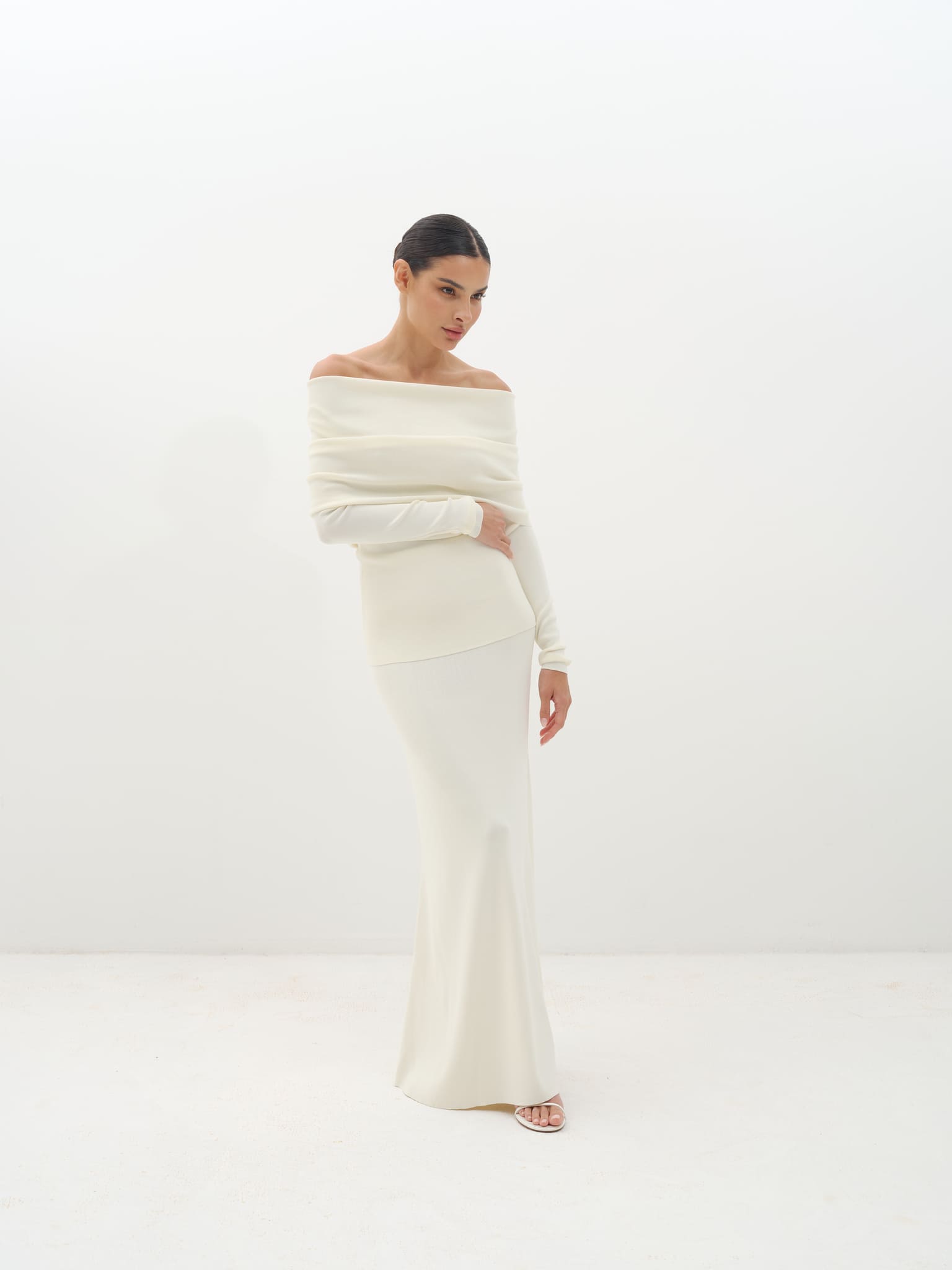 Woman wearing a white off-shoulder set against a white background