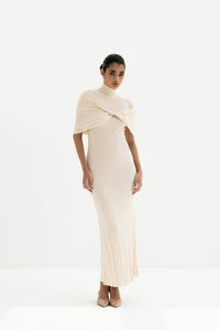Woman wearing a white ribbed dress with a draped effect on a white background