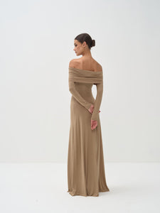 Woman wearing a long, off-shoulder beige dress on a white background