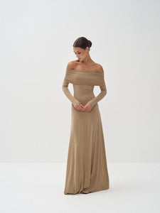 Woman wearing a beige off-shoulder gown on a white background