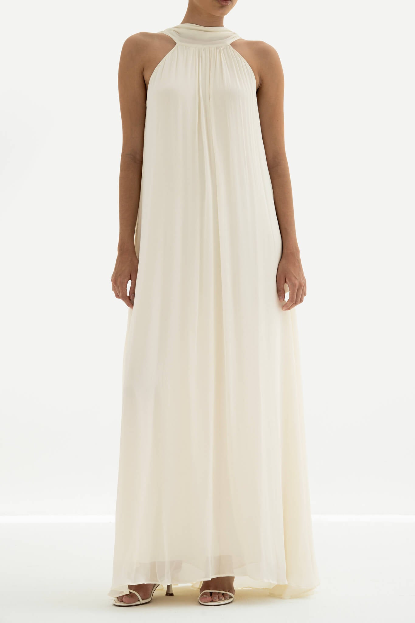 Woman wearing a long white dress against a white background