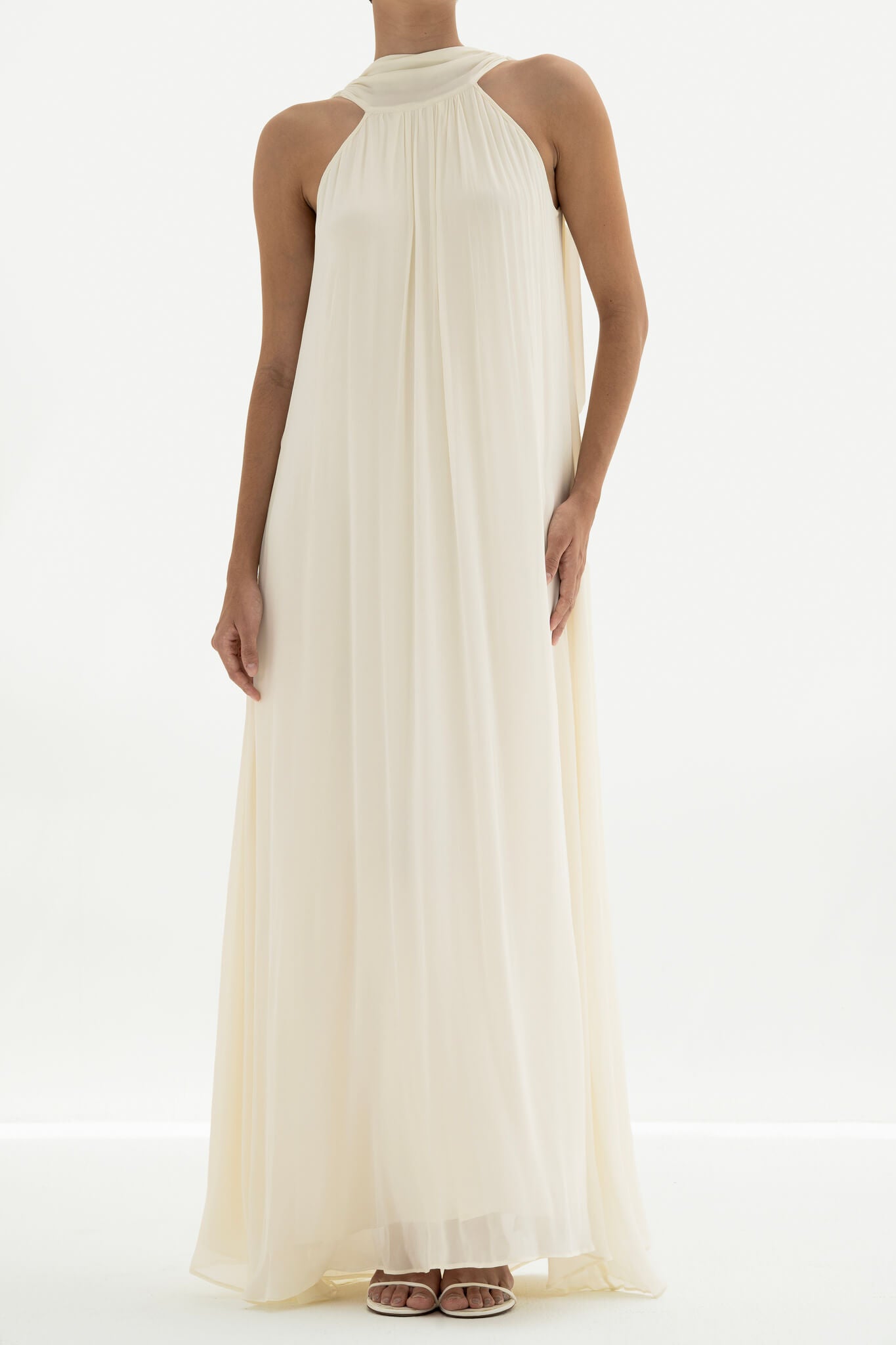 Woman wearing a long white dress against a white background