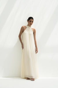 Woman wearing a long white dress against a white background