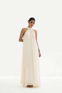Woman wearing a long white dress against a white background