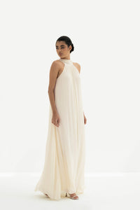 Woman wearing a long white dress against a white background