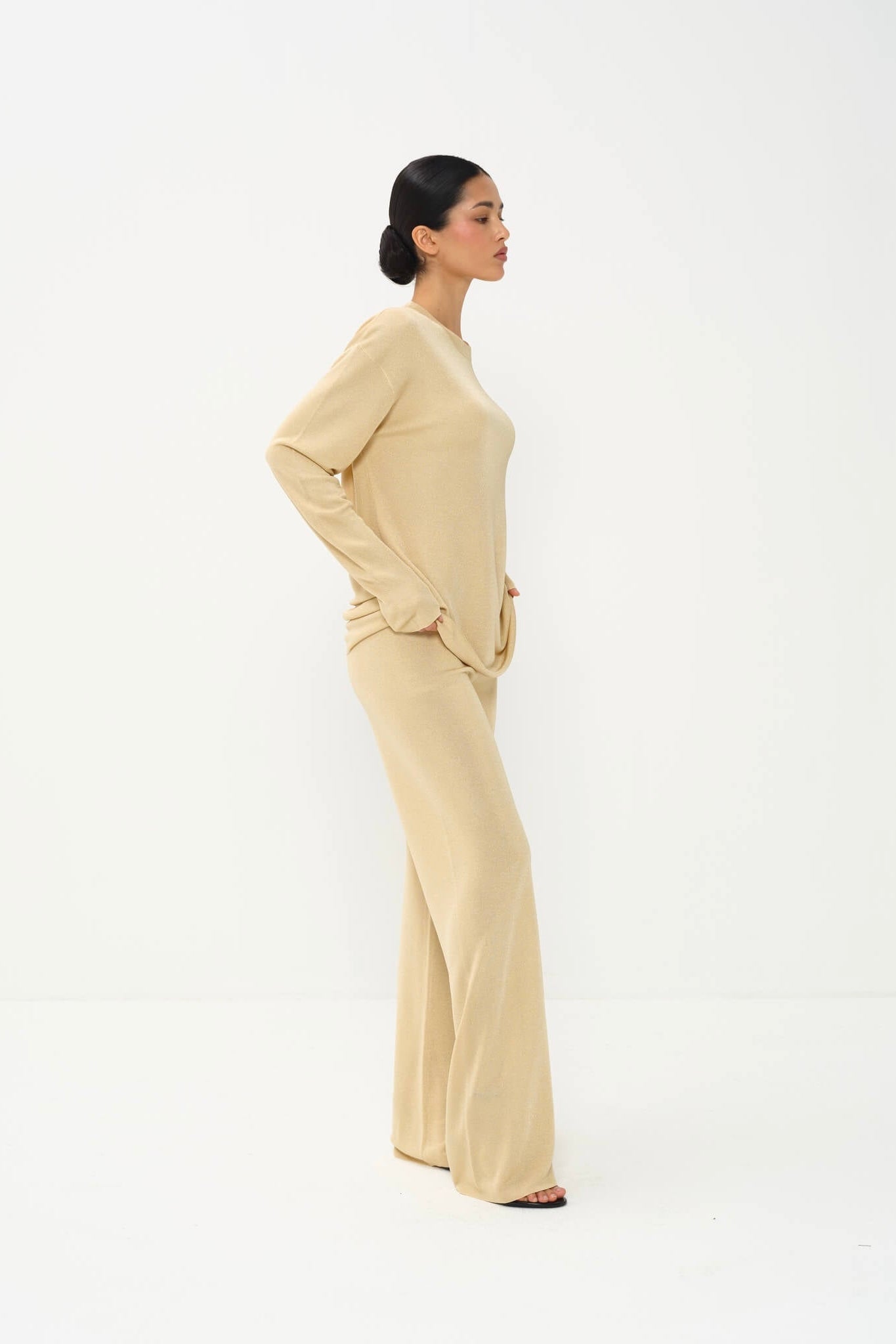 Woman wearing a beige outfit on a white background