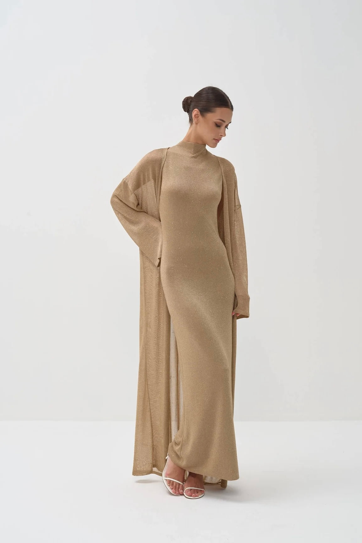Woman wearing a long beige dress set on a white background