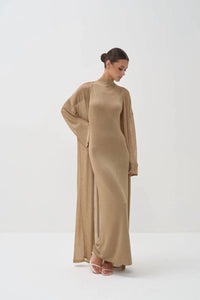 Woman wearing a long beige dress set on a white background