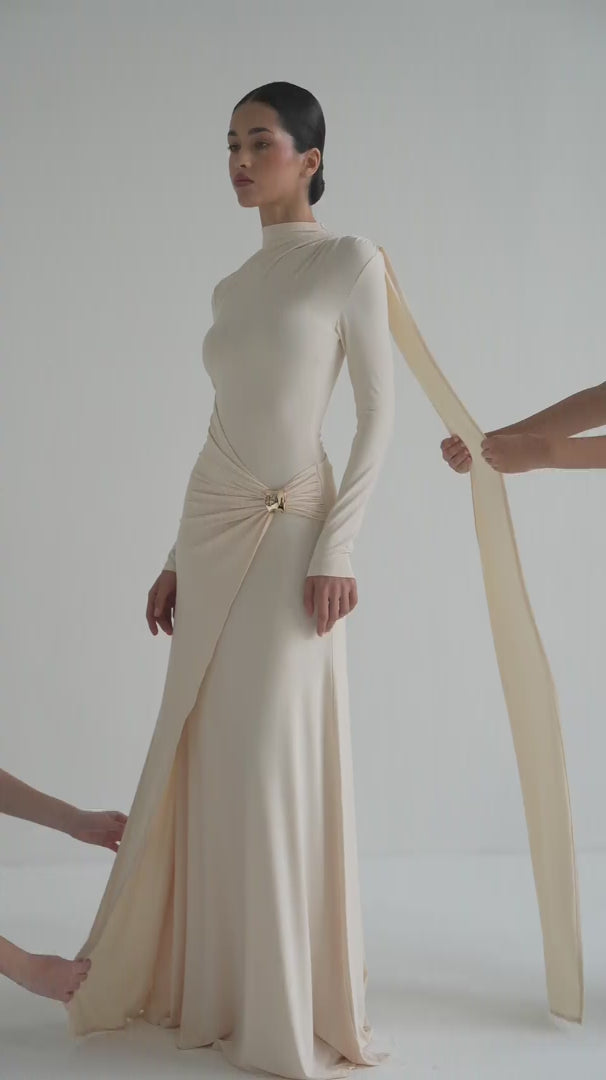 Woman wearing a long, light-colored dress on a white background