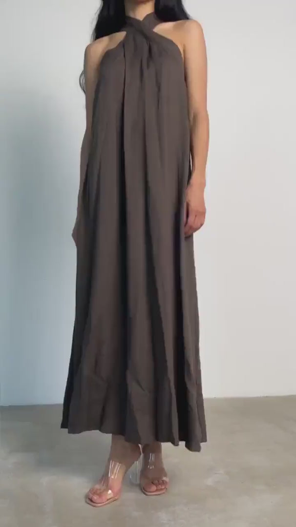 A woman models the Mélina linen maxi dress in brown, exuding sophistication.