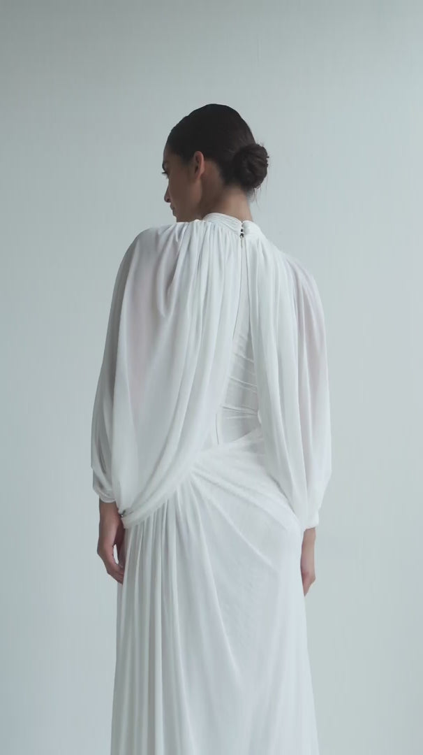 White pleated dress with draped shoulders on a white background