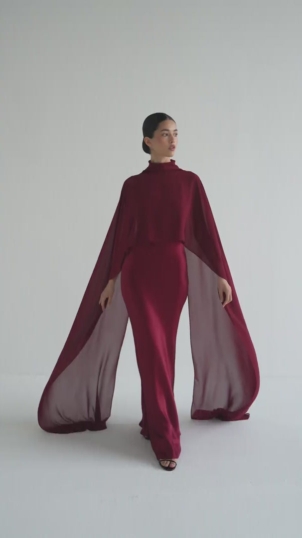 Woman wearing a burgundy dress and cape